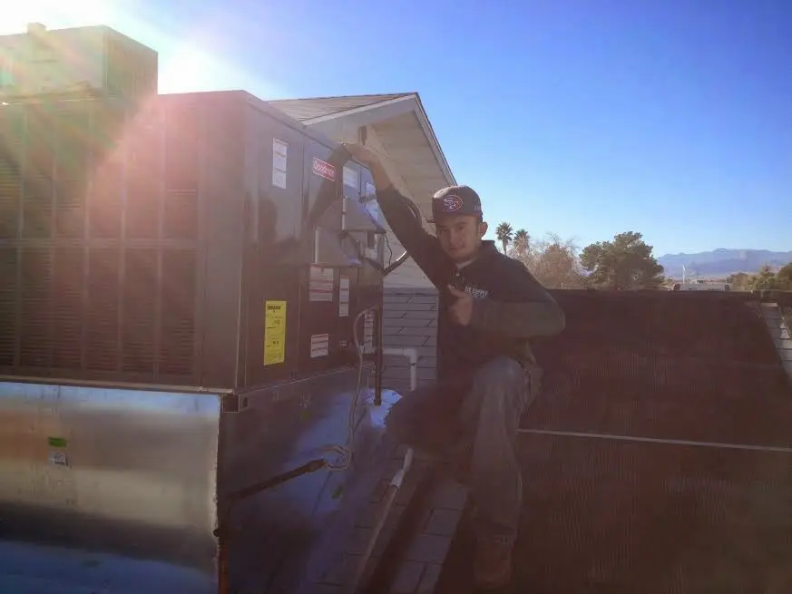 HVAC technician performing Air Duct Cleaning on a rooftop unit in Alamo Heights